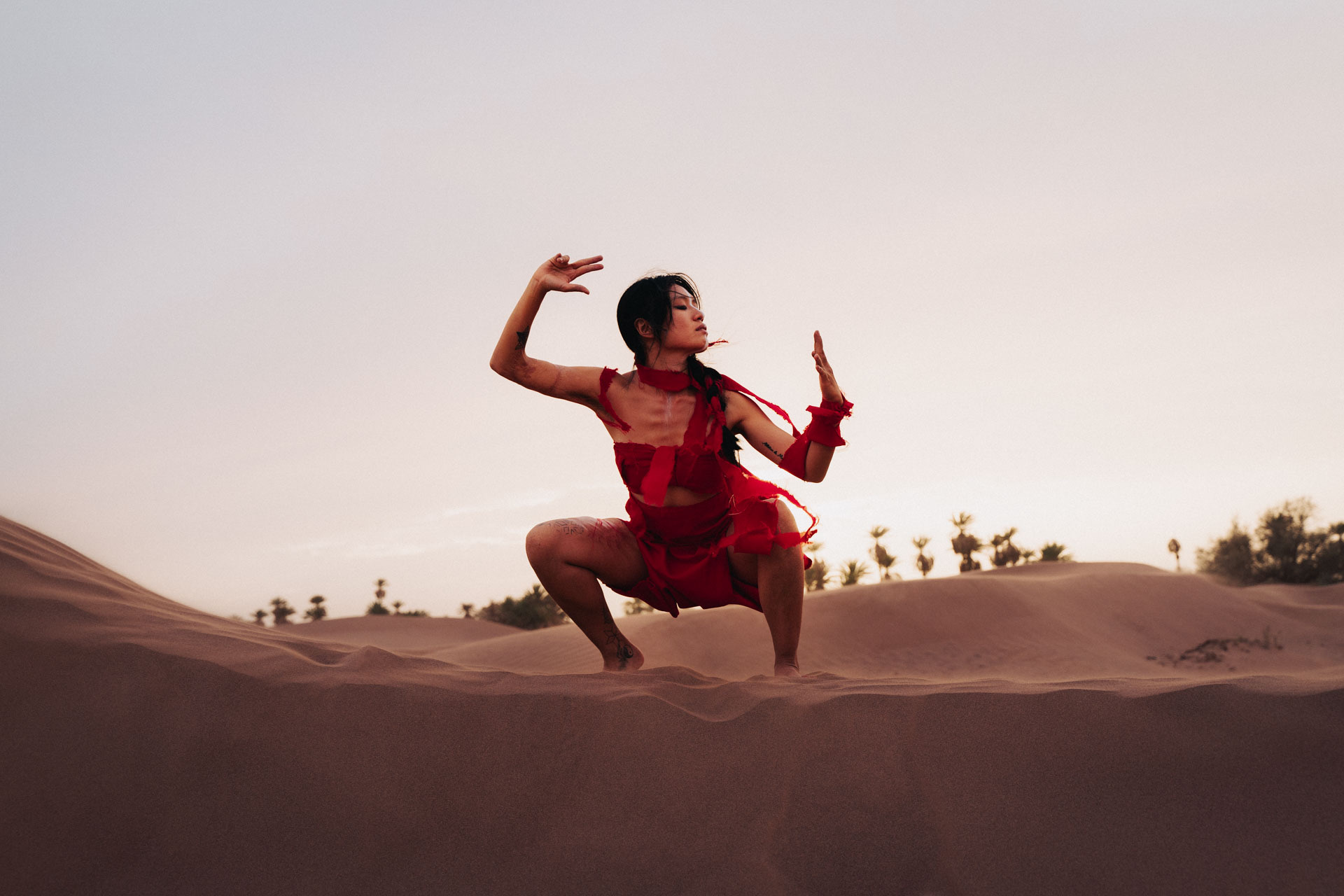 Yi Chen dancing on a dune in the Sahara